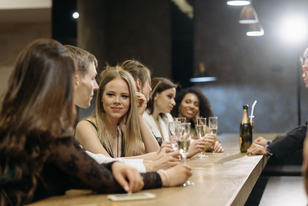 Man confidently talking with a group of women at a bar
